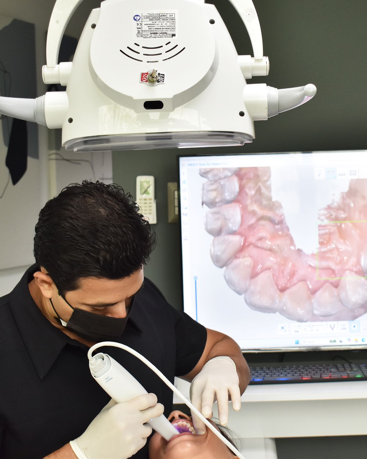 El Dr. Noé Martínez toma una impresión digital con el escáner intraoral mientras el modelo 3D aparece en pantalla
